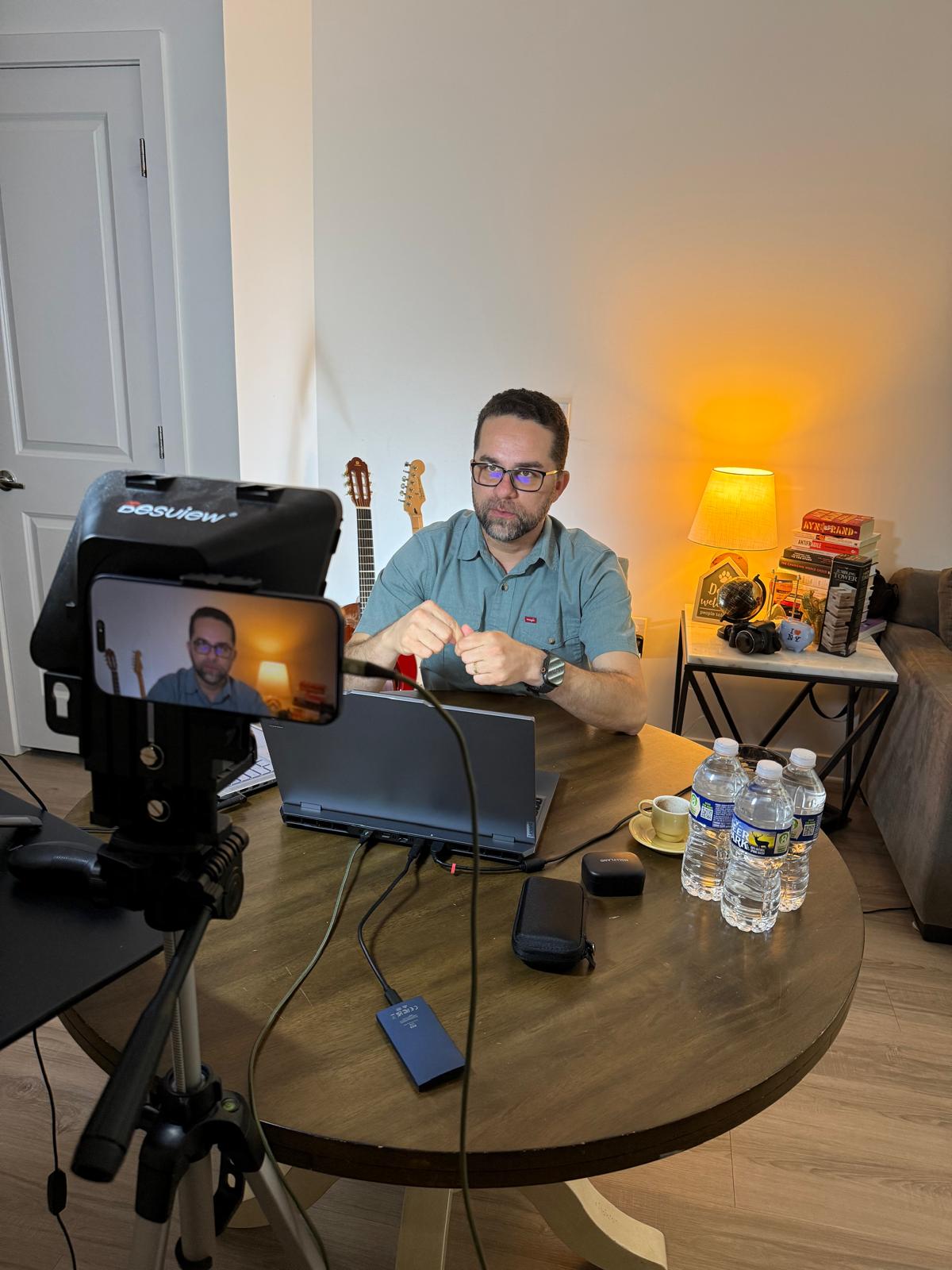 Aula ao vivo sendo transmitida: câmera no tripé, notebook e o professor em cena